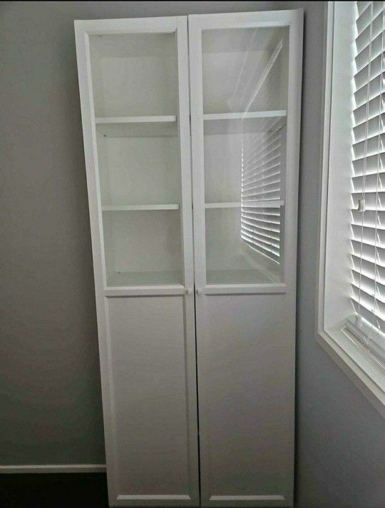 Tall white cabinet with glass doors and shelves.
Ikea Bookcase with panel glass doors
31.5 × 11.75 × 79.5 "