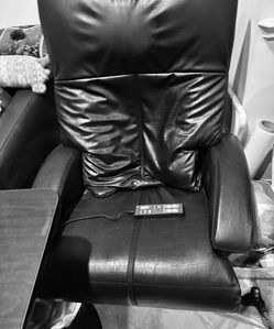 Black leather massage chair with foot rest