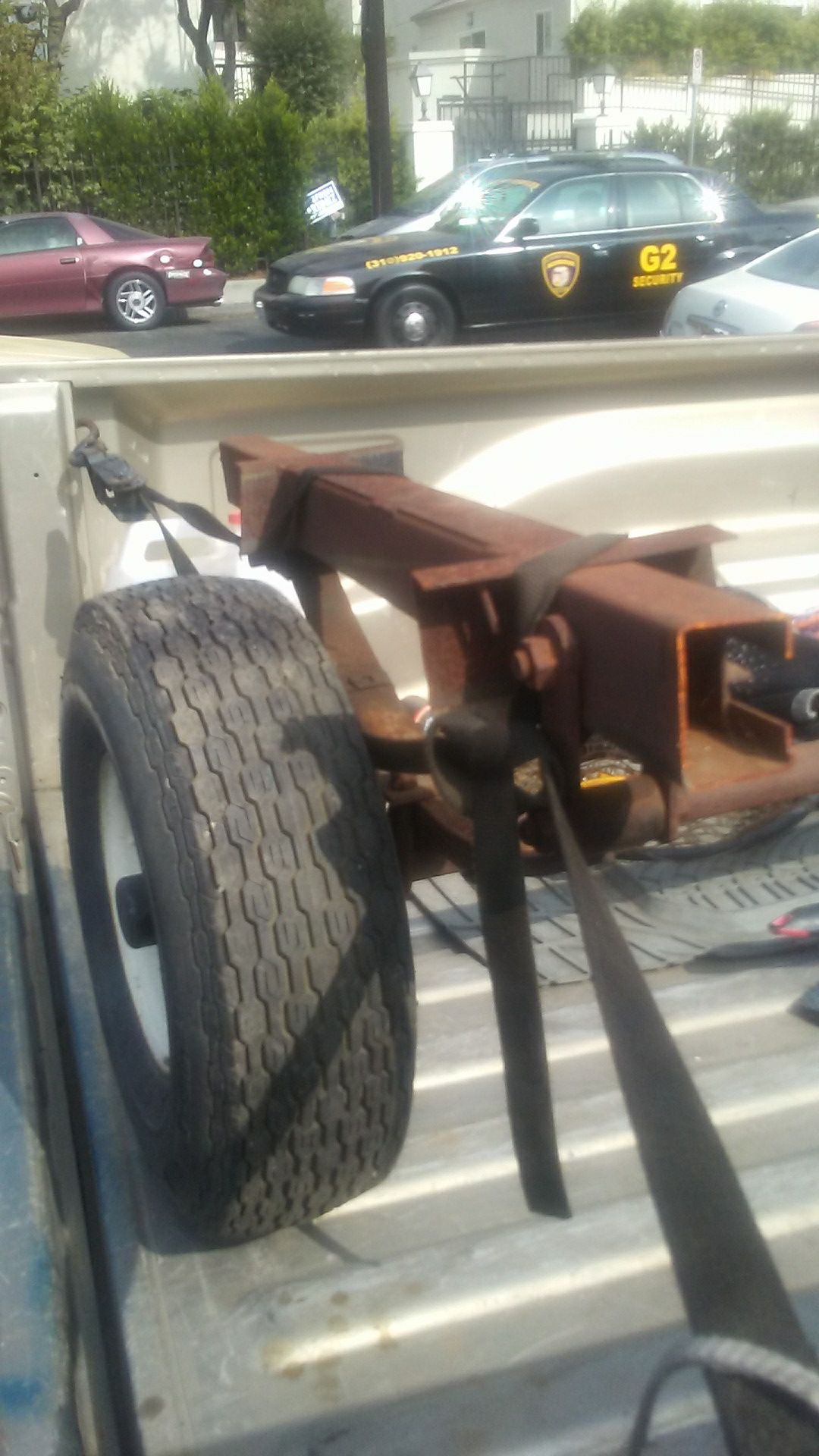 This is a trailer axle with. Leaf springs and shackles and wheels and tires