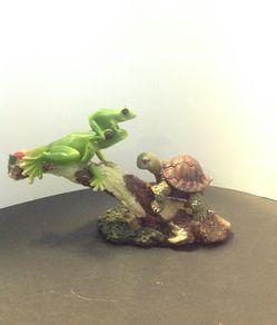 Two frogs and a turtle on a tree branch