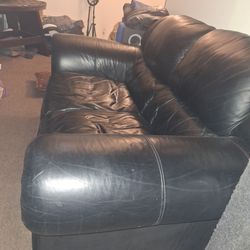 Tuscan black leather love seat.