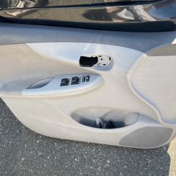 Driver side door panel for 2008 Toyota Corolla with electric window control in the door and the handle