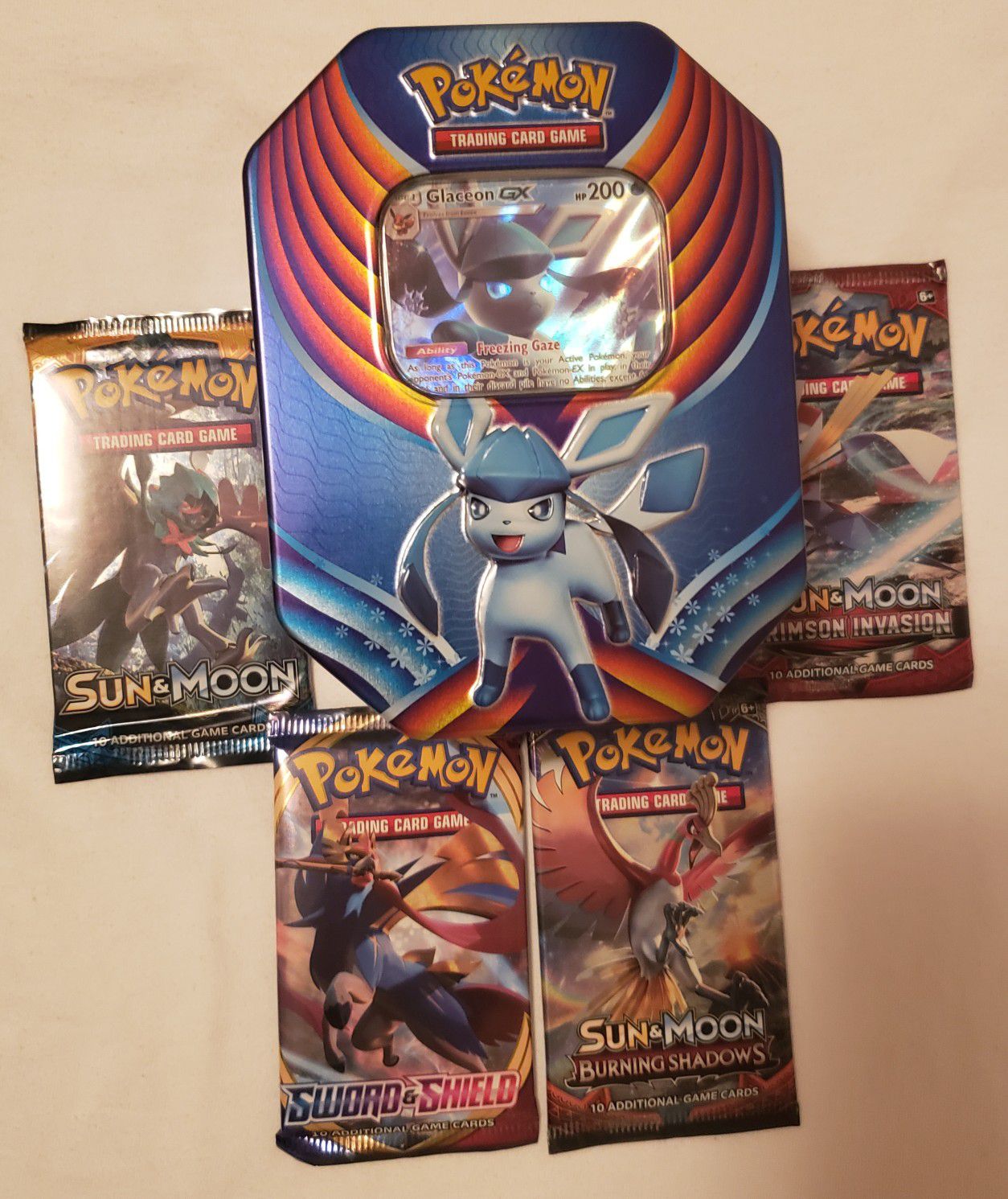 Pokemon tins with 4 brand new booster packs