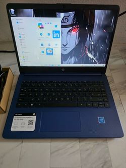 Blue HP laptop with Intel processor, full keyboard, and Windows 11. Original sticker still attached. Charger included. Clean condition with no visible
