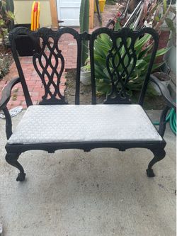 two-seater bench features a Chippendale style