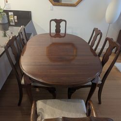 Queen Anne style oval cherry wood table with upholstered chairs