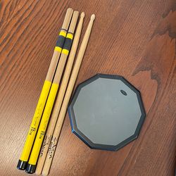 2 sets of drumsticks and percussion practice pad