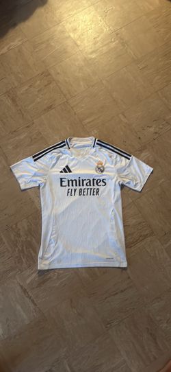 white adidas Real Madrid 2024-25 home jersey featuring black stripes and "Emirates Fly Better" brand