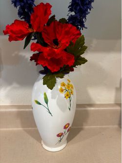 10” white ceramic vase with red yellow and blue flowers on it