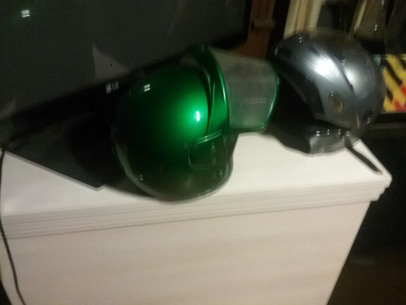 Two motorcycle helmets one modular one custom green candy