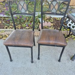 iron dining chairs with integrated stone accents and faux crocodile leather seat cushions.
