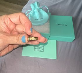 Tiffany & Co. ring with three diamonds and a gold-tone finish.