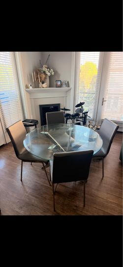 Glass round dining table with 4 grey chairs