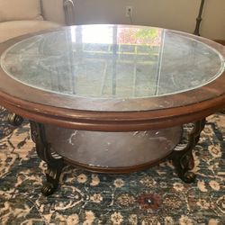 Round wooden coffee table with glass top.