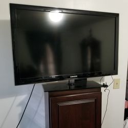 Samsung Television With Keyboard Remotes And Glass Stand