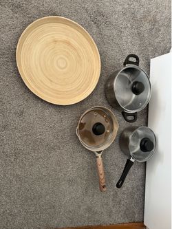 A set of pots, a frying pan, and a wooden tray, all for $20.
