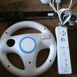 Black Wii With Cables.  1 Steering Wheel 1 Nunchuck 1 Controller 1 Key Pad