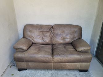 Brown leather couch/loveseat and outdoor rug