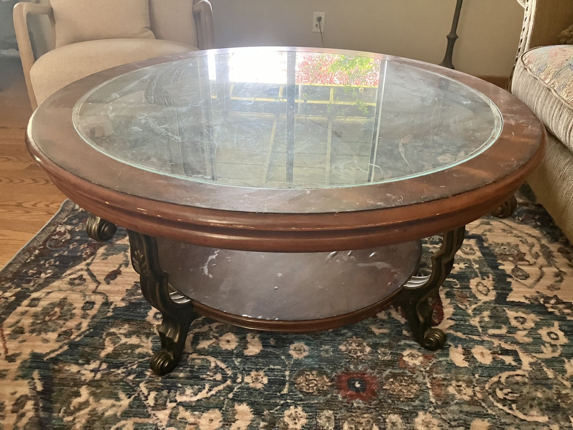 Round wooden coffee table with glass top.