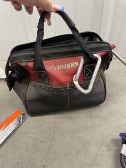 red and black Husky tool tote bag with random things inside