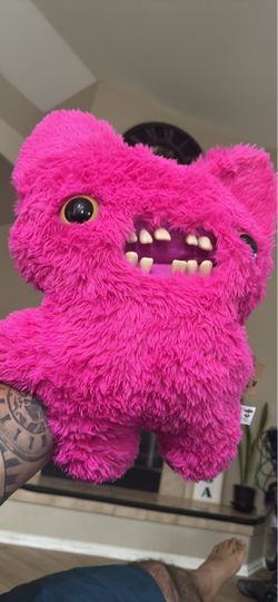 New Zuru Fuggler Bigg Fugg Screech plush is made of pink polyester faux fur. This 17-inch monster features human-like teeth and plastic eyes. It has t