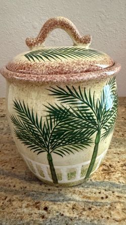 Beautiful large ceramic kitchen canister featuring a tropical palm tree design in cream, green and earthy brown tones.