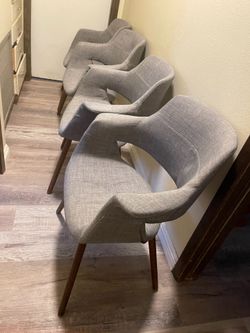 Cuatro sillas grises modernas para comedor regular.