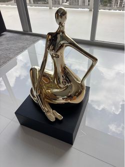 Sculpture of a Naked silver lady on dark wood pedestal