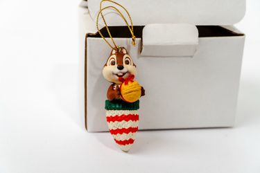 Cute chip of chip n dale ornament holding a nut with a red bow