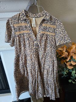 Lightweight tiered dress with short sleeves. Button-front styling and small collar. All-over leopard print in tan and black. Feminine ruffle tiers. Gr