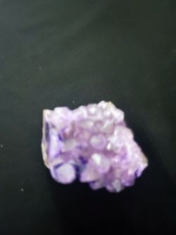 Purple amethyst crystal cluster specimen has a natural crystalline structure with a white matrix base.