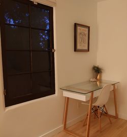 Modern glass top desk with wooden legs, plus white desk chair