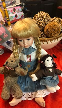 Blonde porcelain doll with teddy bear and stuffed doll