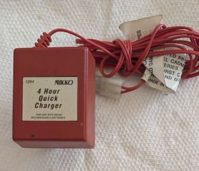 The Nikko 4 Hour Quick Charger Model 1294 is a vintage red plastic AC charger built for 9.6V NiCd (Nickel-Cadmium) rechargeable battery packs used in