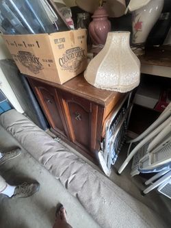 That’s a small vintage wood cabinet/TV stand style piece—looks like solid wood with decorative panel doors (nice detail 👍).