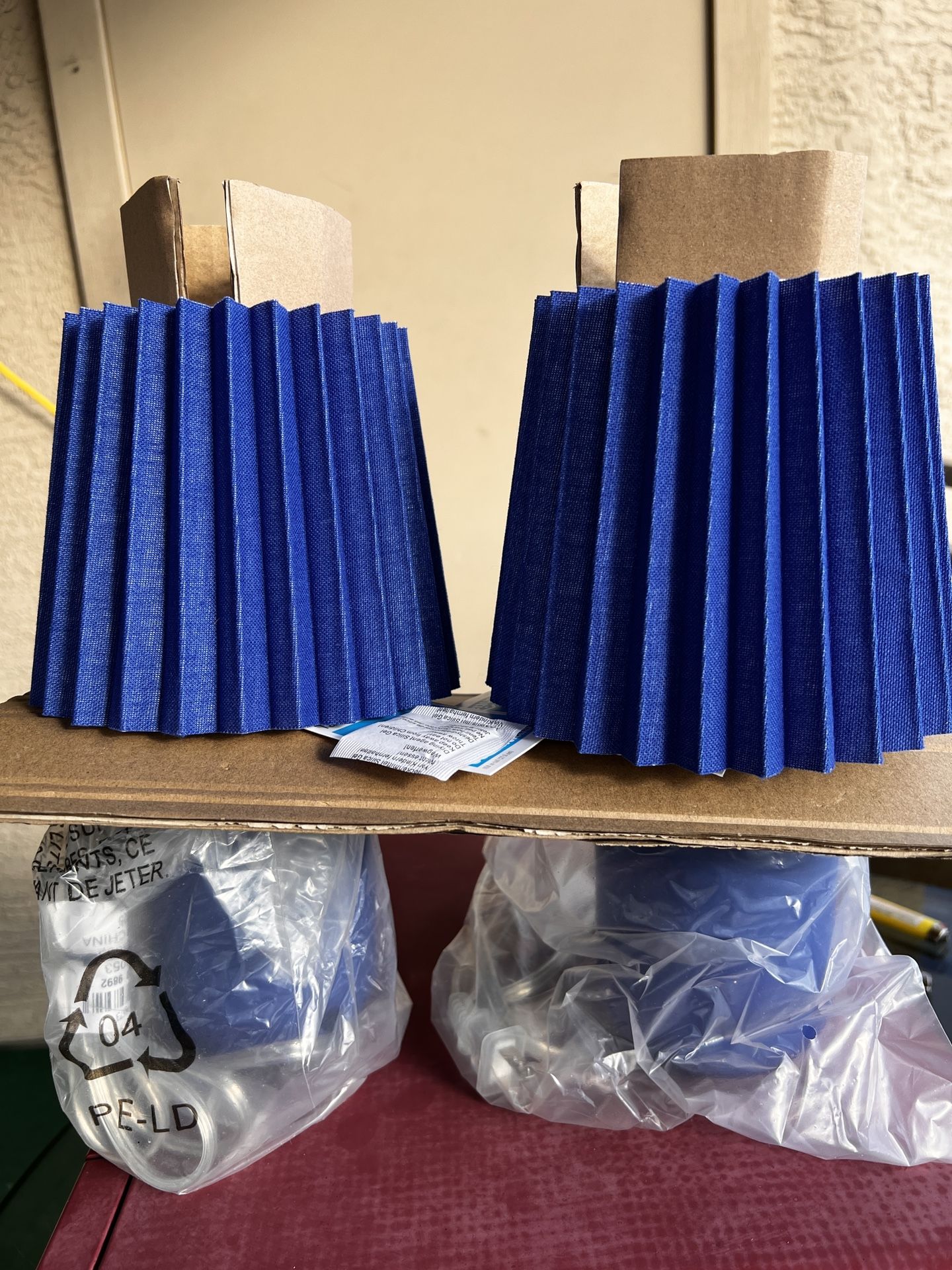 Two new table lamps with blue pleated mesh shades.