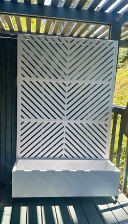 White Metal Planter box with trellis and wheels.
