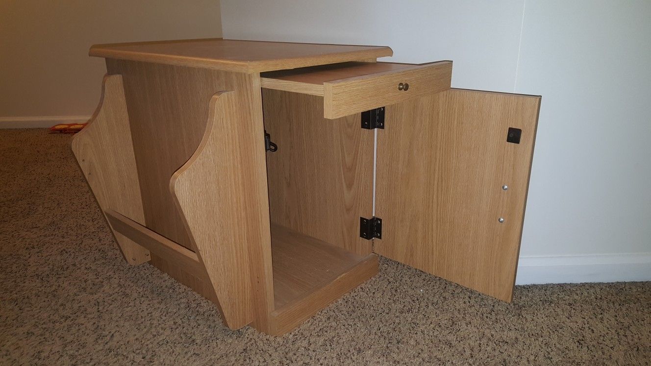 End table with magazine rack, sliding shelf, and cabinet.