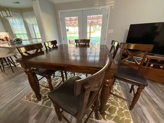 Wooden high top/ bar top table set with 6 leather padded chairs and rug