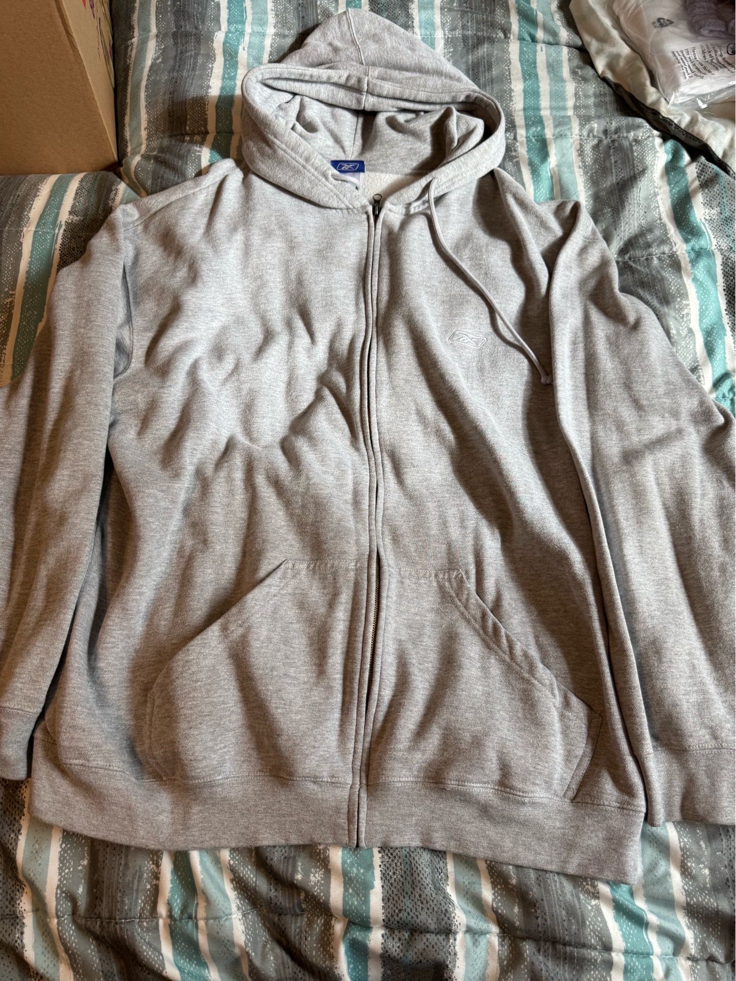 Grey Reebok full-zip hoodie with a small embroidered logo on the chest.SIZE 2XLT