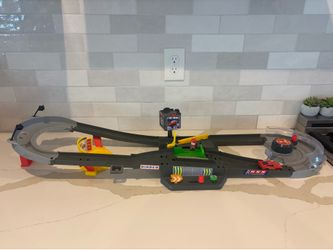 Disney Pixar Cars Piston Cup Action Speedway playset features a wind-up booster and pit stop area for interactive racing
