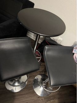 3-piece pub set features a round black table and two backless adjustable stools