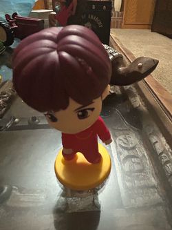 Character: j-hope (from the K-pop group BTS's animated character line, TinyTAN)Design: Stylized figure wearing a red outfit mounted on a round yellow 