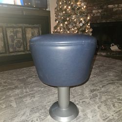 It is a blue stool with a round seat and a metal base. 