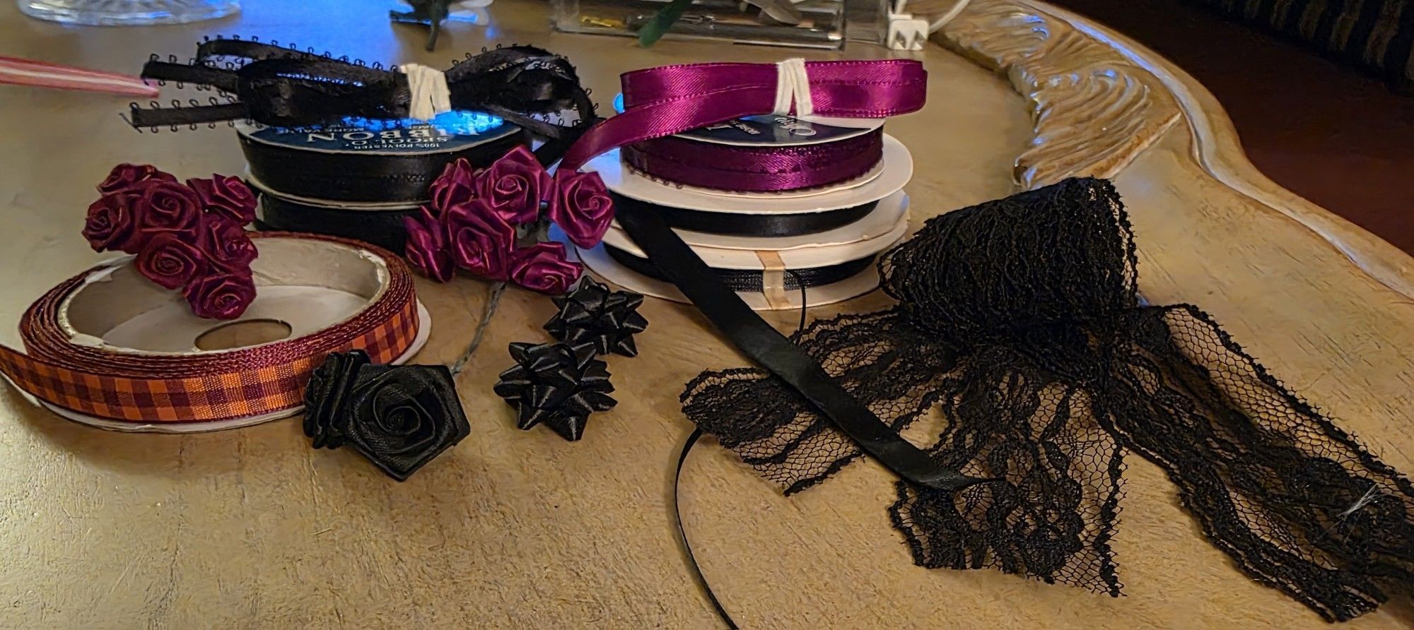 Black And Garnet Satin Ribbon Spools, Lace Strips, And Silk Flower Rosettes