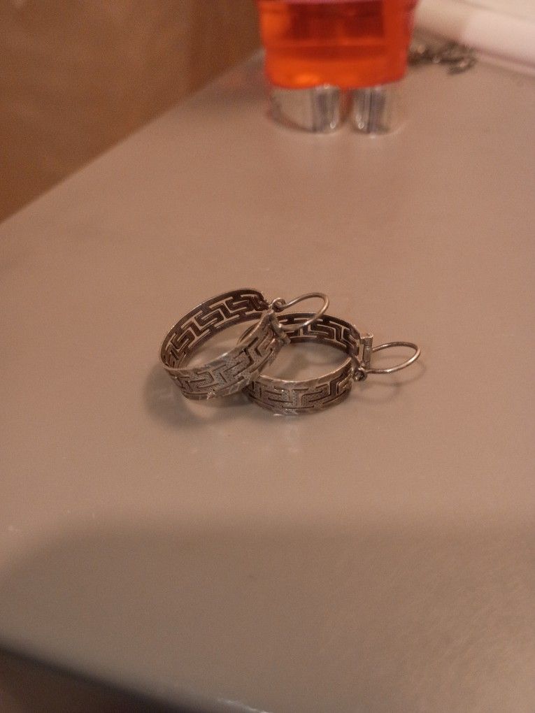 vintage sterling silver hoop earrings with a labyrinthine pattern.