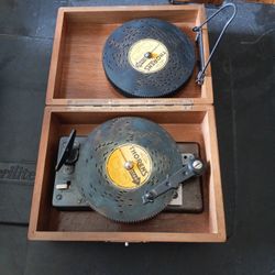 a vintage mechanical music player that uses metal discs with punched patterns to create music