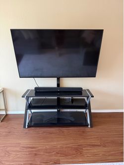 Large Vizio Smart TV With Soundbar and Modern Glass TV Stand