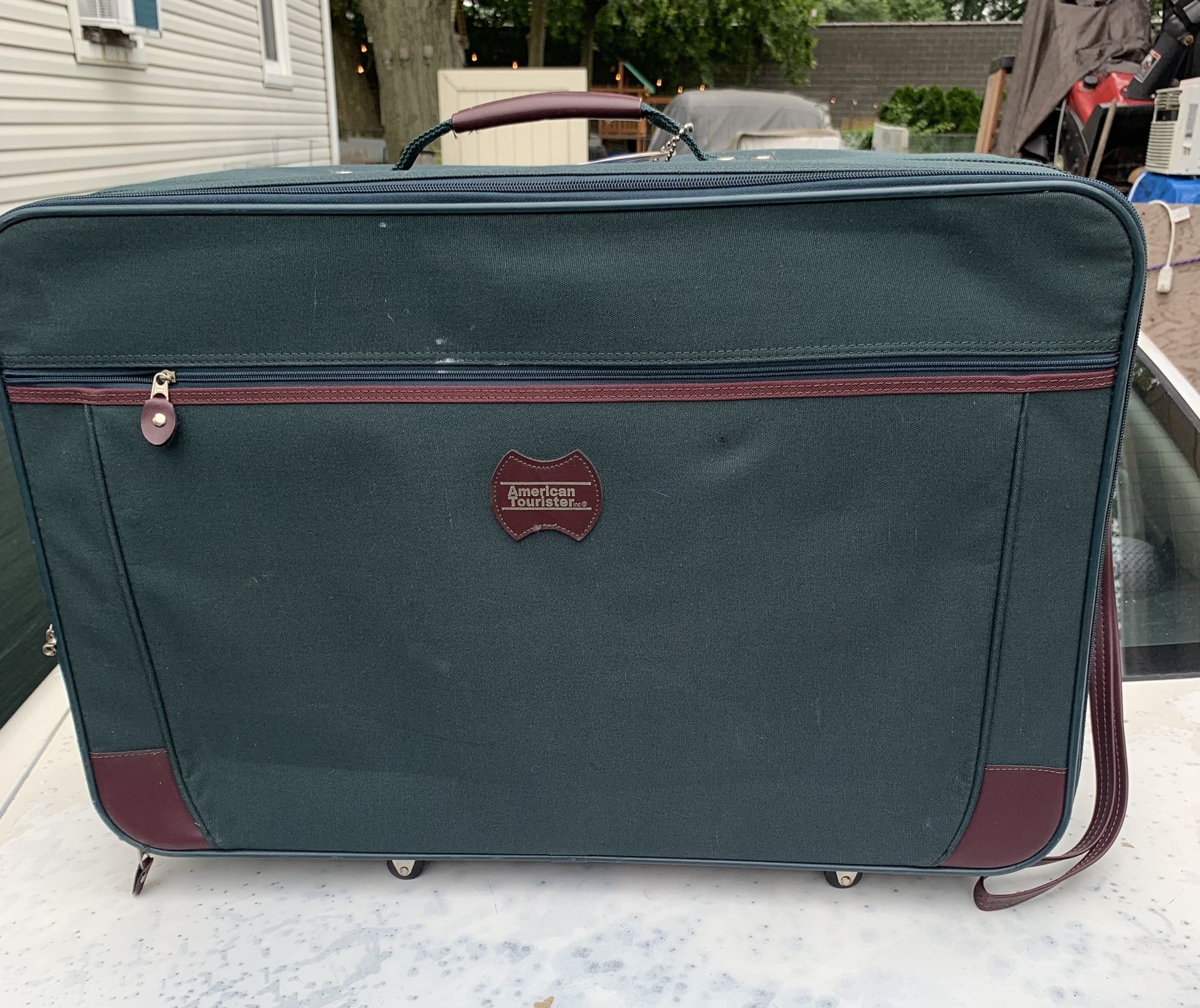 Suitcase, American tourist 26 wide 17 tall 8 deep has wheels two zipper compartments on lid