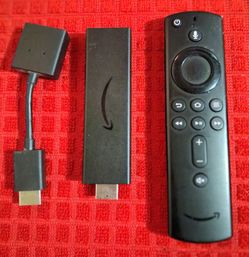 Amazon Fire TV Stick 4k media streaming device, an HDMI extension cable, and an Alexa Voice Remote
